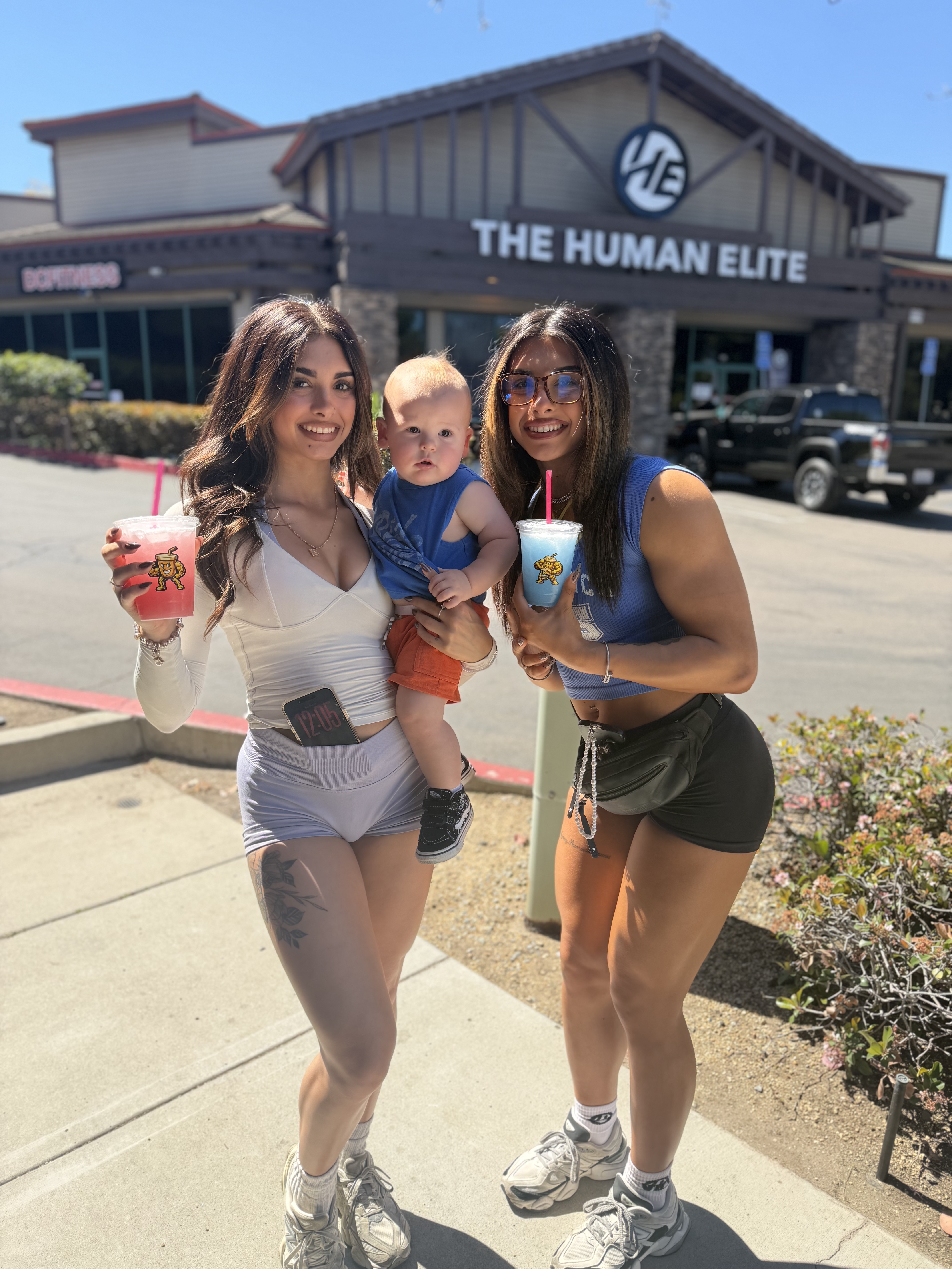 Moms and a baby holding Muscle Lounge smoothies outside the shop
